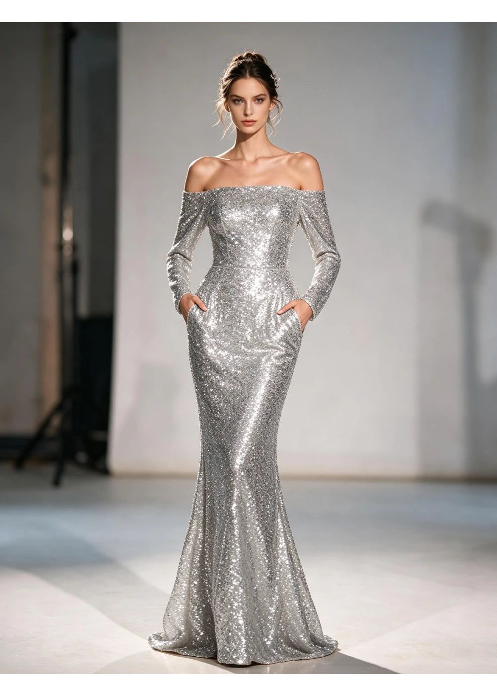 Front view of a silver off-shoulder sequin mermaid gown with long sleeves