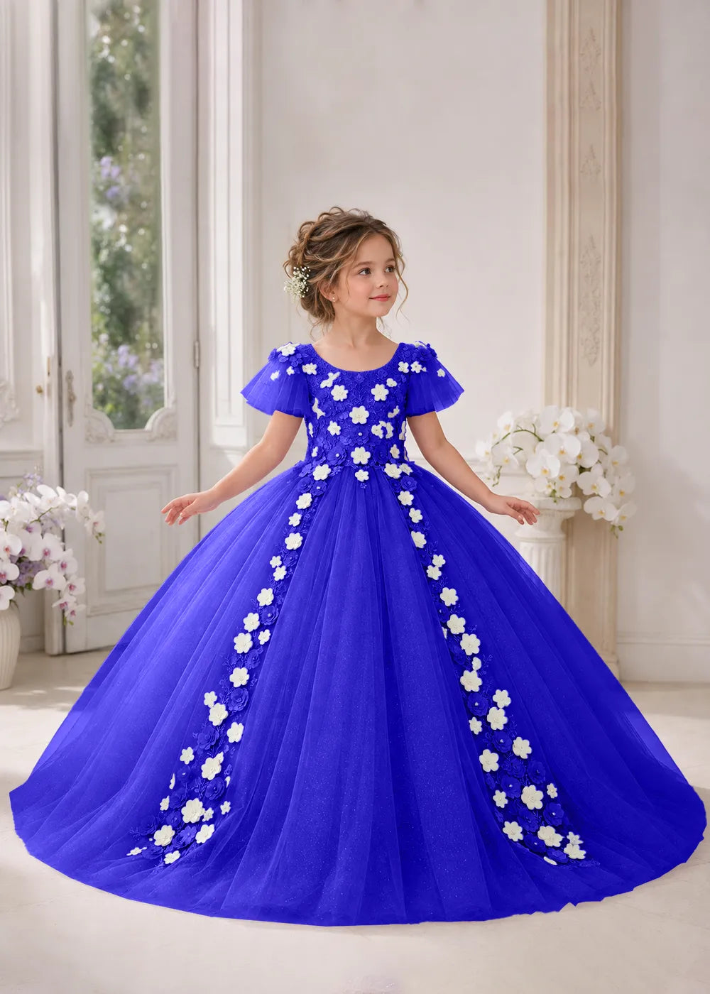 Front view of a child wearing a deep royal blue flower girl dress with a round neckline, sheer flutter cap sleeves and a floral vine cascading down both sides of a full tulle skirt.