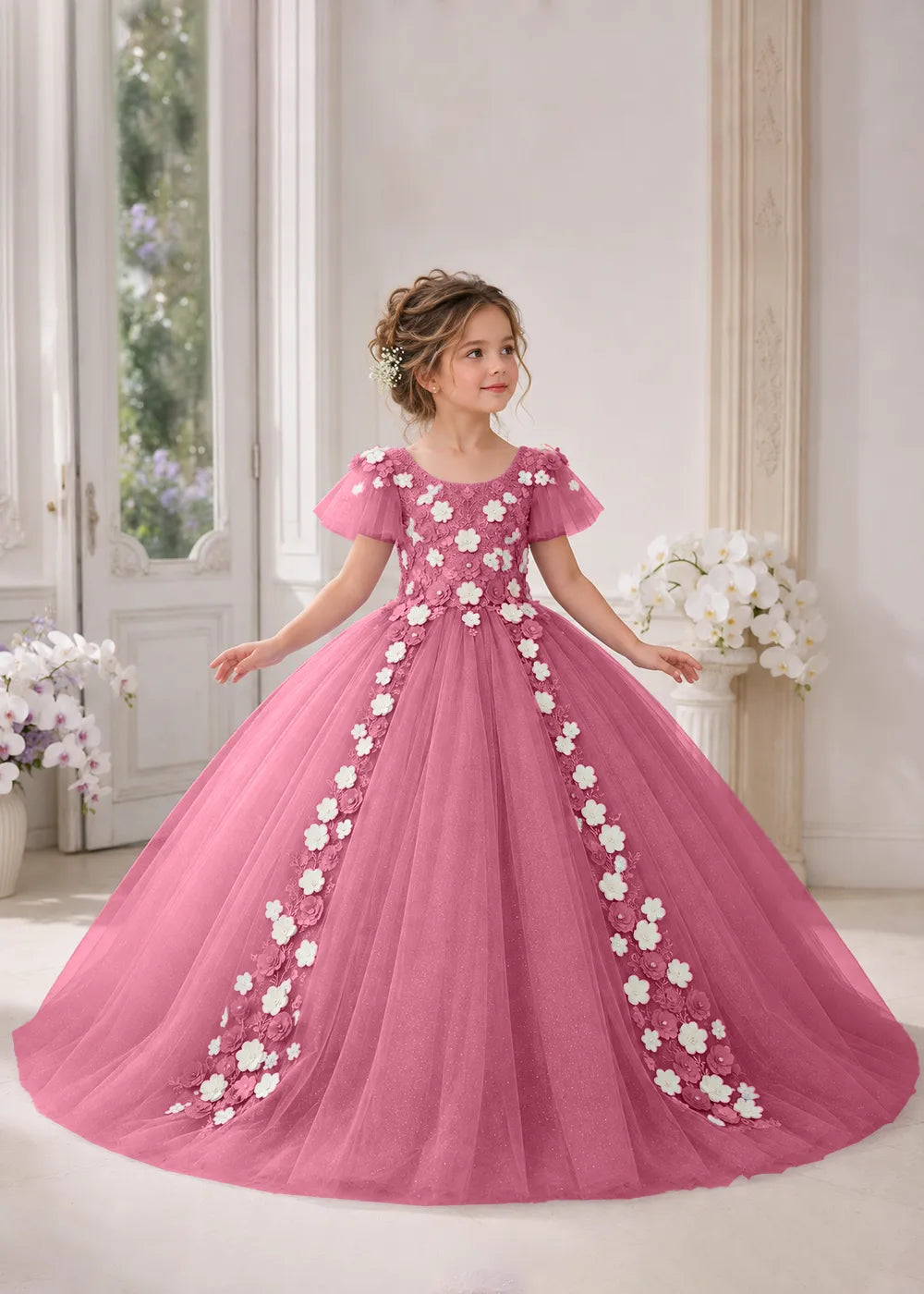 Front view of a child wearing a desert rose flower girl dress with a round neckline, sheer flutter cap sleeves and a floral vine cascading down both sides of a full tulle skirt.