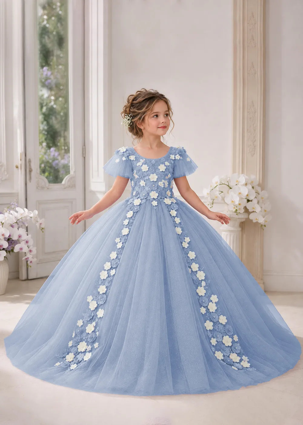 Front view of a child wearing a dusty blue flower girl dress with a round neckline, sheer flutter cap sleeves and a floral vine cascading down both sides of a full tulle skirt.