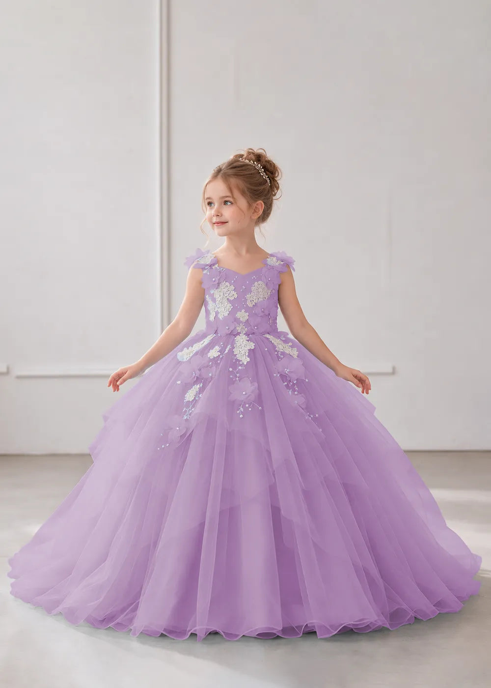 Front view of a child wearing a lilac flower girl dress with a V-neckline, floral shoulder appliques and lace and flower decoration across the bodice and hips.