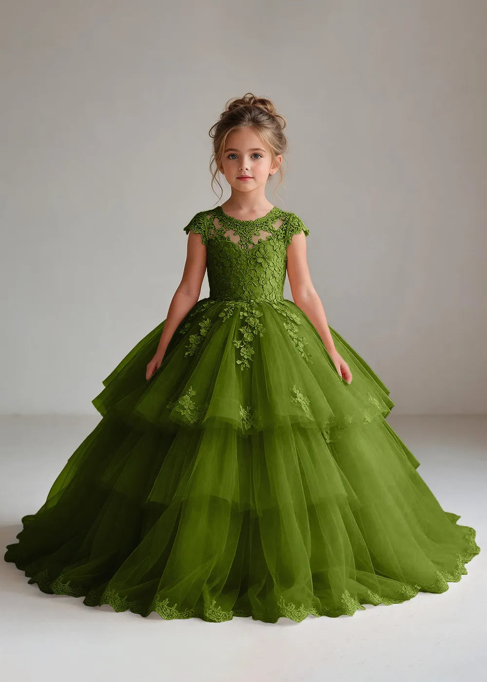 Front view of a child wearing a olive flower girl dress with a sheer lace illusion neckline, cap sleeves and a tiered cake-style tulle skirt with a lace-trimmed hem.