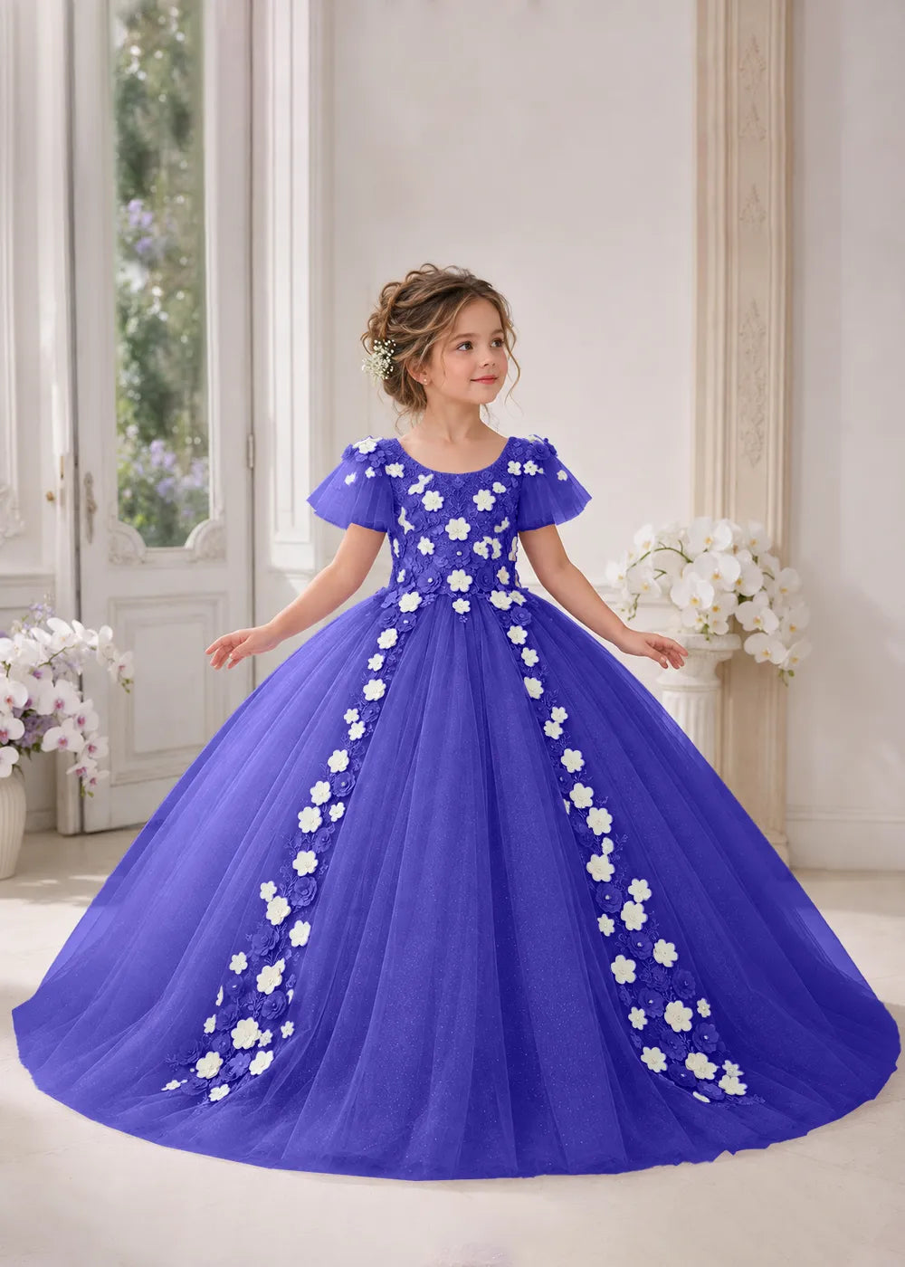 Front view of a child wearing a royal blue flower girl dress with a round neckline, sheer flutter cap sleeves and a floral vine cascading down both sides of a full tulle skirt.
