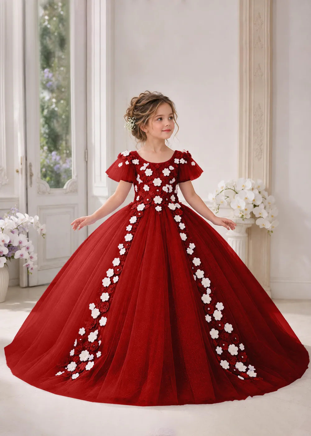 Front view of a child wearing a wine red flower girl dress with a round neckline, sheer flutter cap sleeves and a floral vine cascading down both sides of a full tulle skirt.