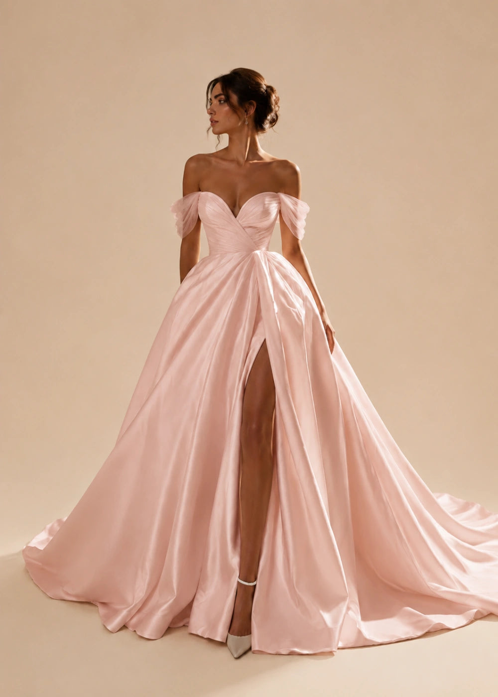 Front view of the blush pink off-the-shoulder A-line gown with a corset bodice, high slit, and train
