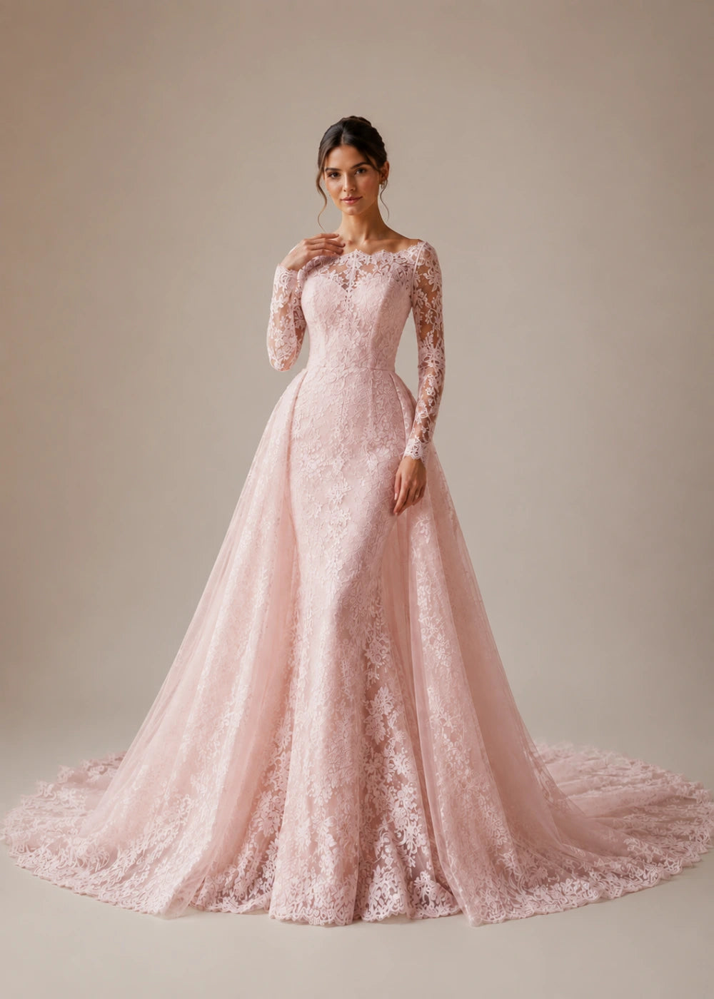 Front view of the blush pink illusion-neck A-line gown with all-over floral lace, long sleeves, and a train