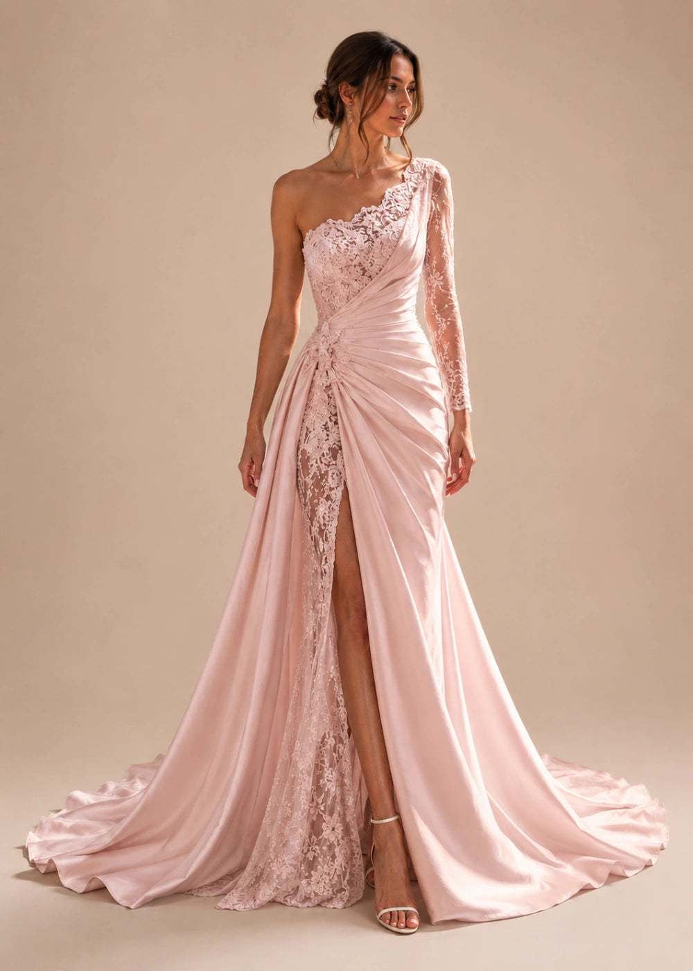 Front view of the blush pink one-shoulder fitted gown with one long lace sleeve, a thigh-high slit, and a train