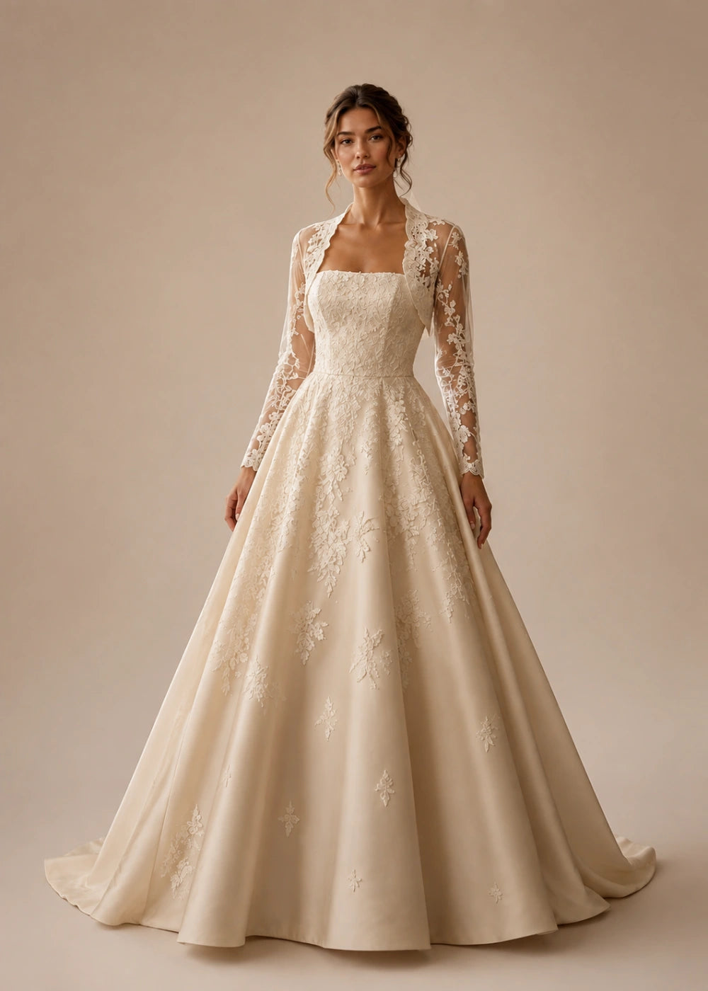 Front view of the champagne square-neck A-line gown with a long-sleeve lace bolero-style overlay