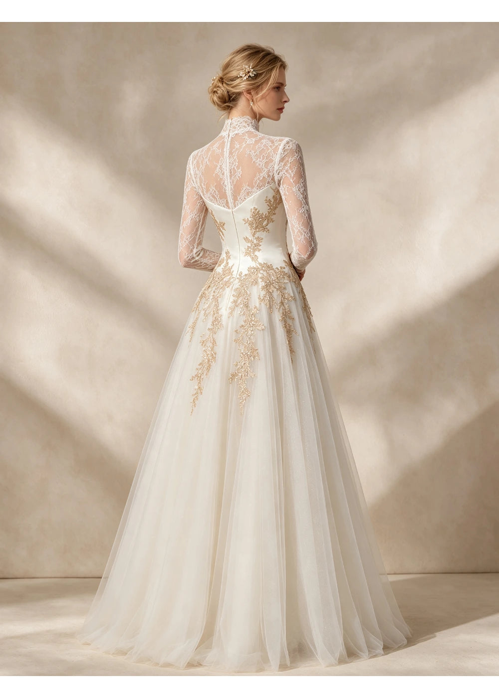 Back view of the ivory gown showing sheer floral lace across the shoulders and gold appliques above the full skirt