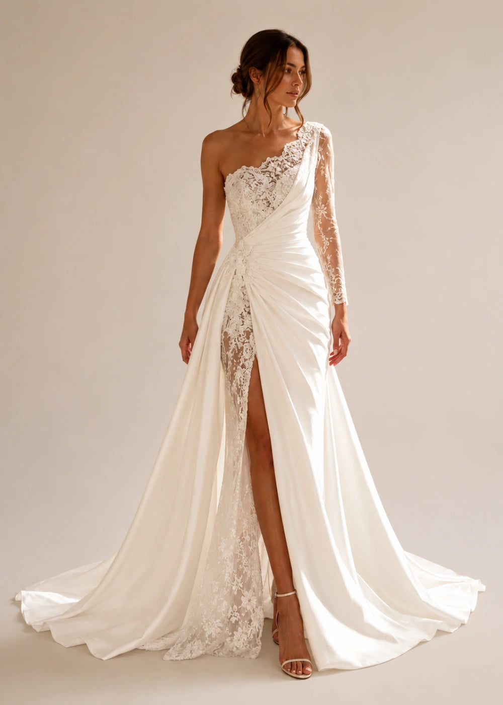 Front view of the ivory one-shoulder fitted gown with one long lace sleeve, a thigh-high slit, and a train