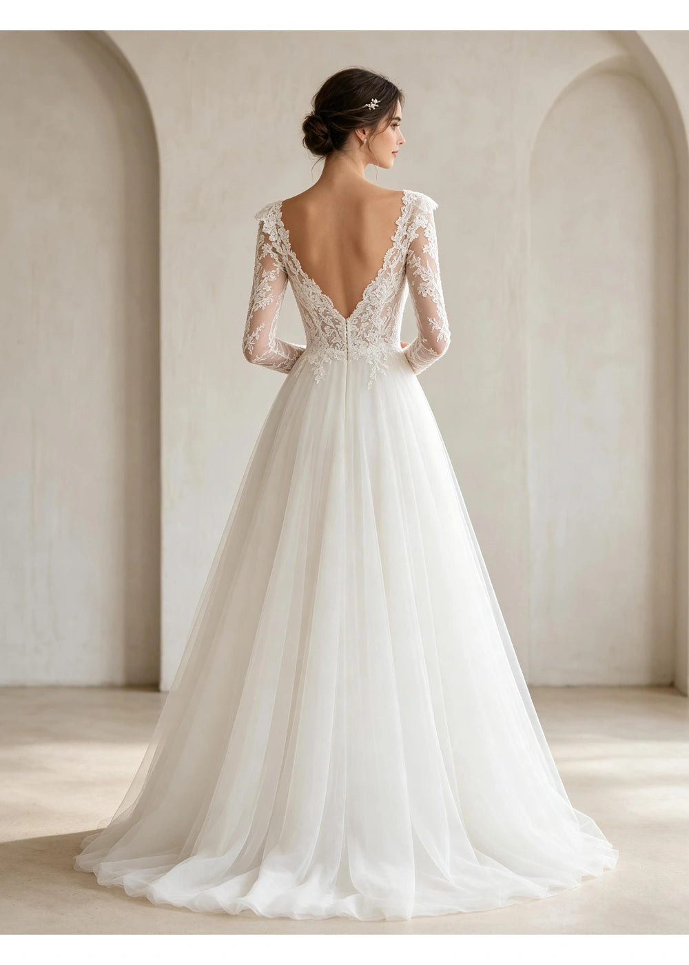 Back view of the white gown showing a low V-shaped neckline and trailing net-style skirt