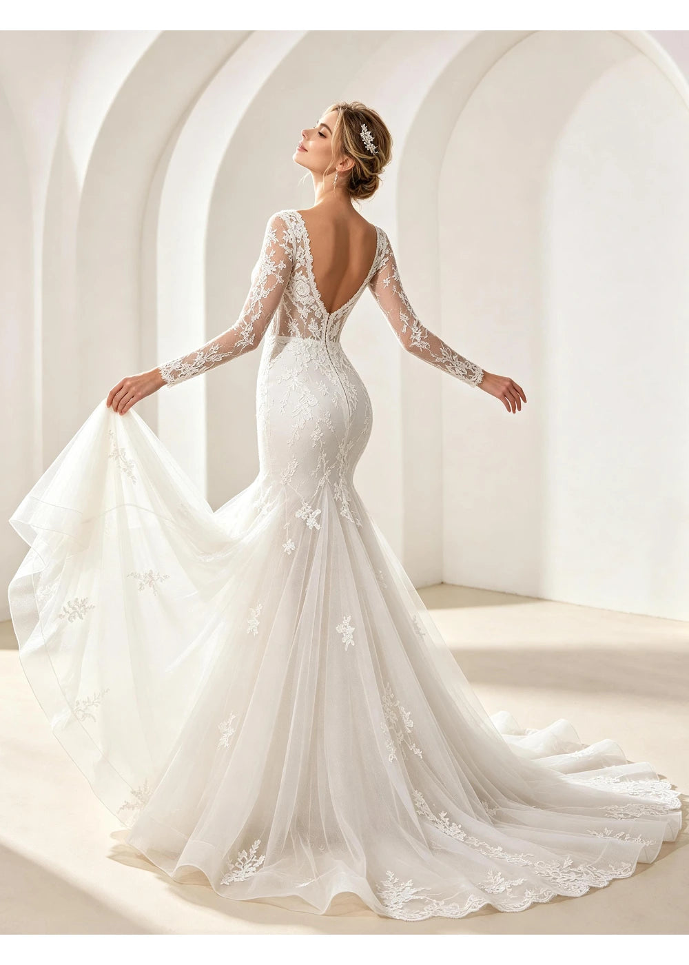 Back view of the white gown showing a low open back and broad lace-edged train