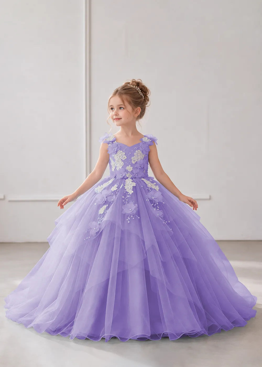Front view of a child wearing a lavender flower girl dress with a V-neckline, floral shoulder appliques and lace and flower decoration across the bodice and hips.
