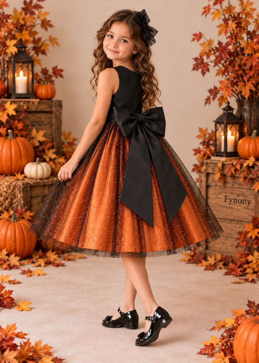 Side-back view of the orange and black dress, showing its large black rear-waist bow and long pointed tails.