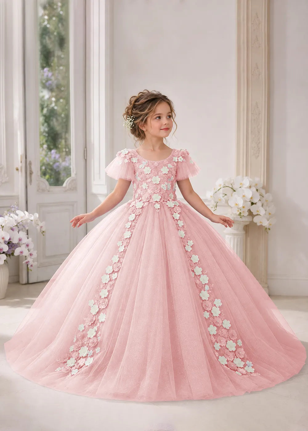 Front view of a child wearing a pink flower girl dress with a round neckline, sheer flutter cap sleeves and a floral vine cascading down both sides of a full tulle skirt.