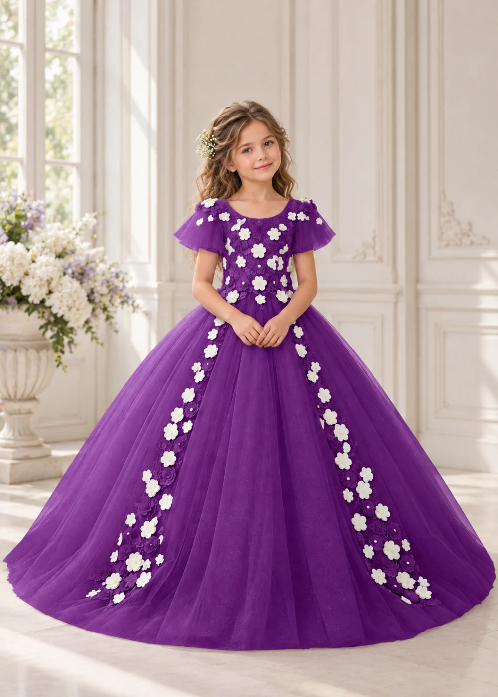 Front view of a child wearing a purple flower girl dress with a round neckline, sheer flutter cap sleeves and a floral vine cascading down both sides of a full tulle skirt.