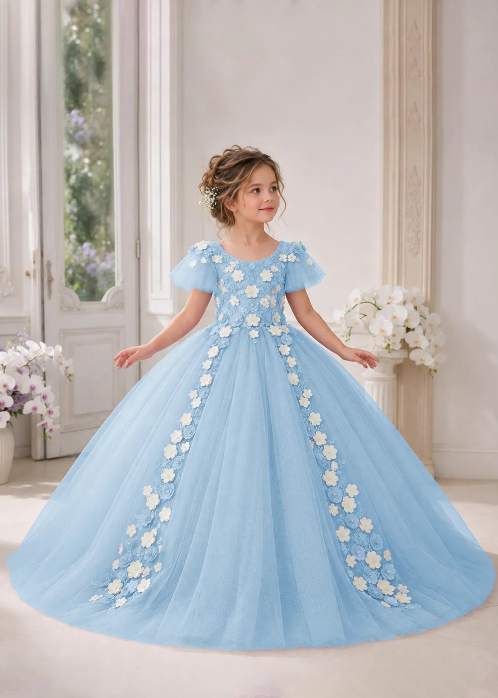 Front view of a child wearing a sky blue flower girl dress with a round neckline, sheer flutter cap sleeves and a floral vine cascading down both sides of a full tulle skirt.