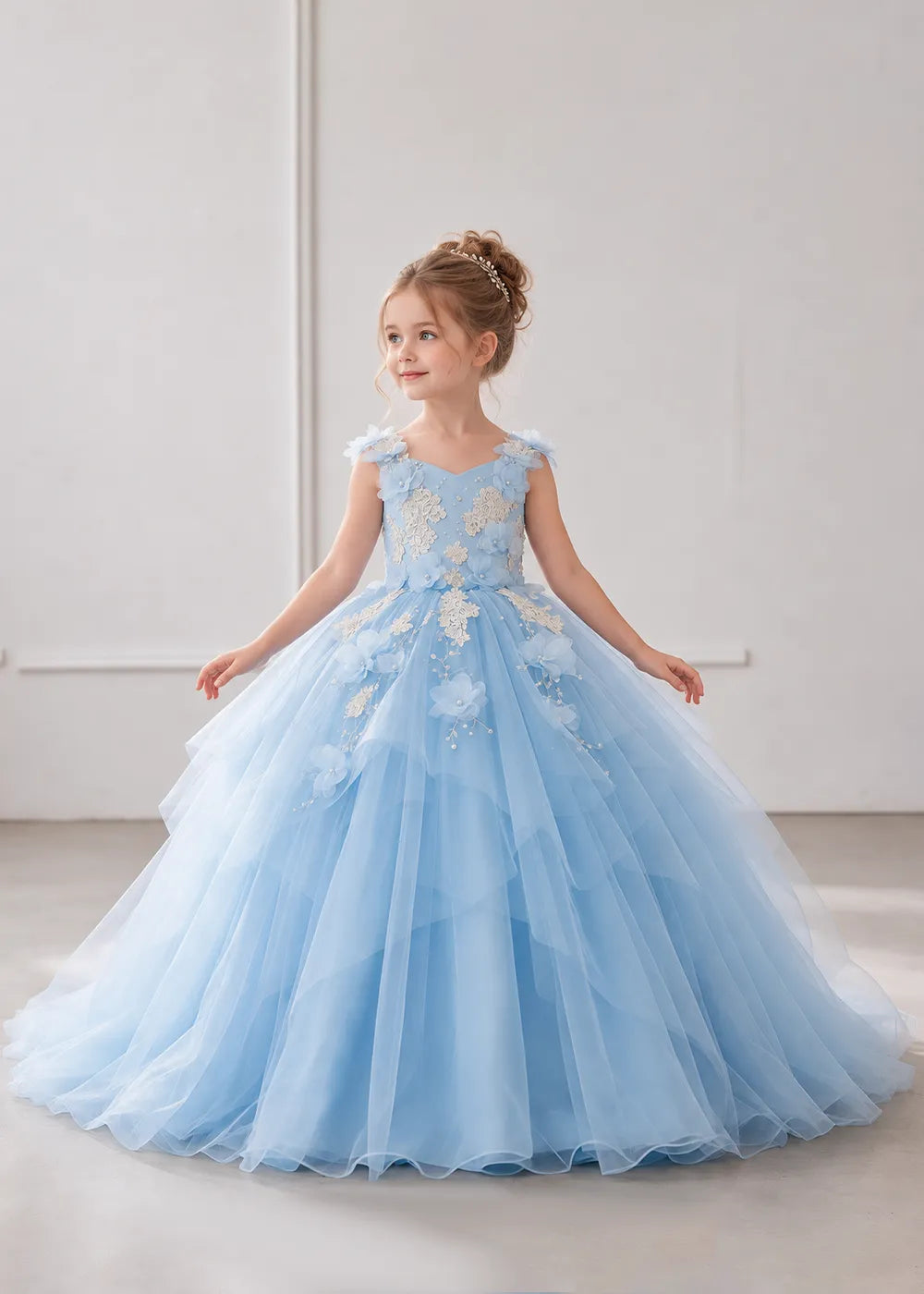 The front view of a child wearing a Sky Blue flower girl dress with a V-neckline, floral shoulder appliques and lace and flower decoration across the bodice and hips.