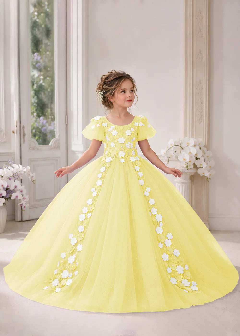 Front view of a child wearing a yellow flower girl dress with a round neckline, sheer flutter cap sleeves and a floral vine cascading down both sides of a full tulle skirt.