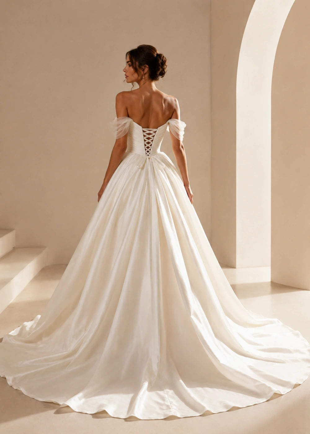 Back view of an ivory off-the-shoulder gown showing corset lacing and a full train