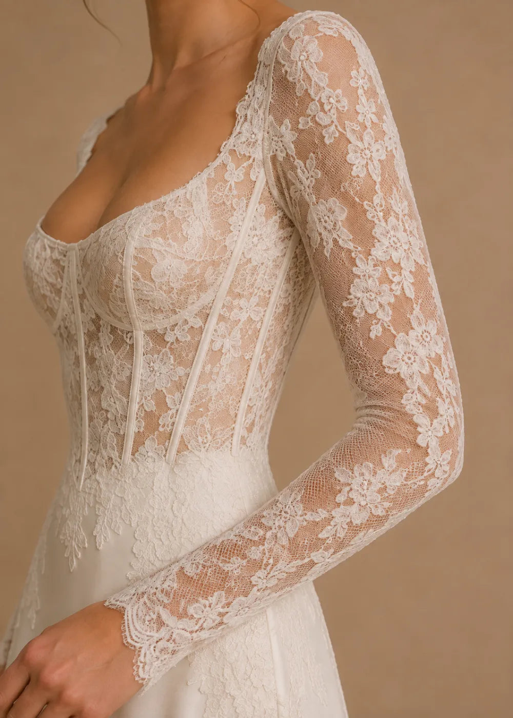 Detail view of the ivory square-neck A-line gown with a lace corset-style bodice, long sleeves, and a train