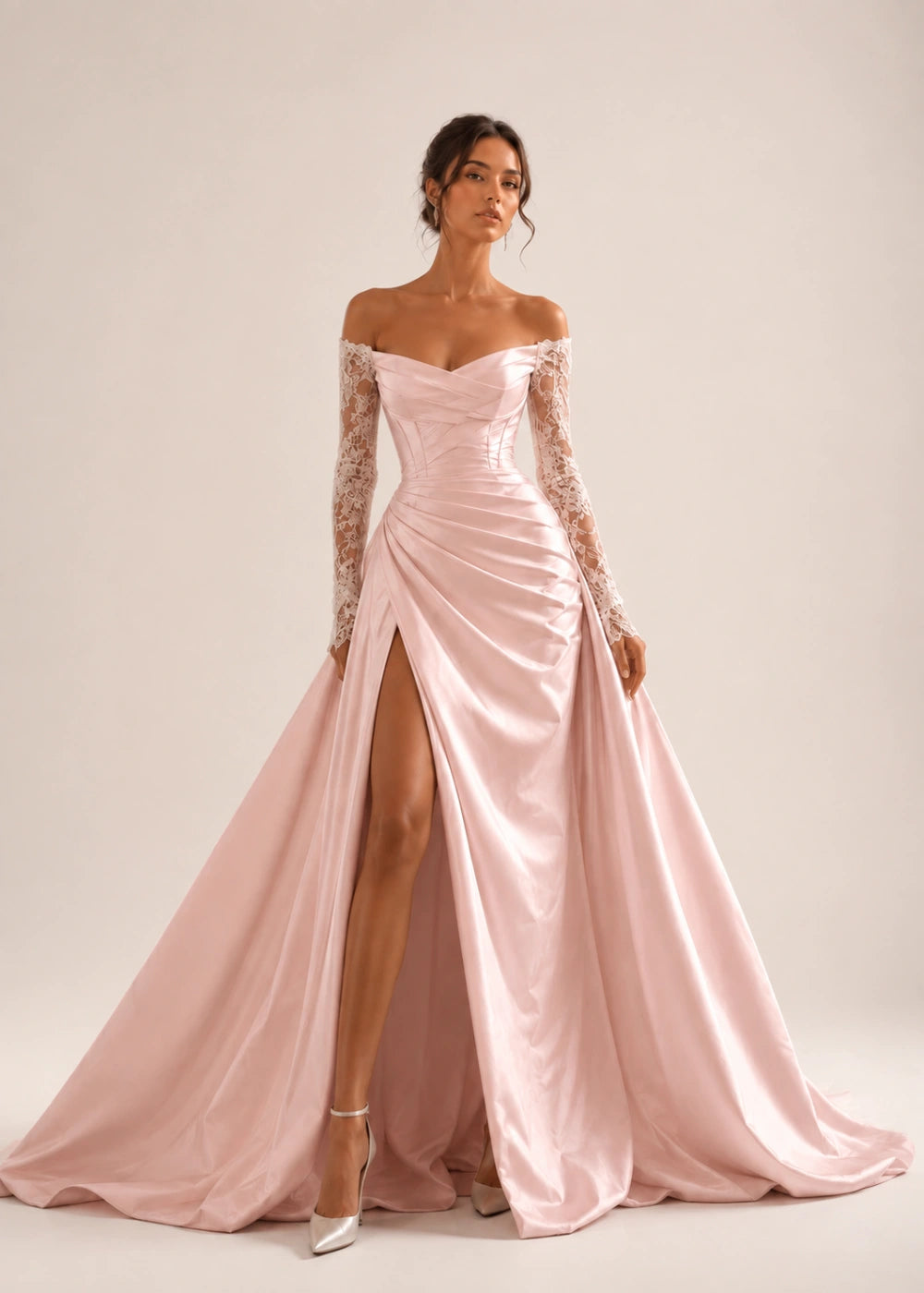 Front view of the blush pink off-the-shoulder A-line gown with long lace sleeves and a thigh-high slit
