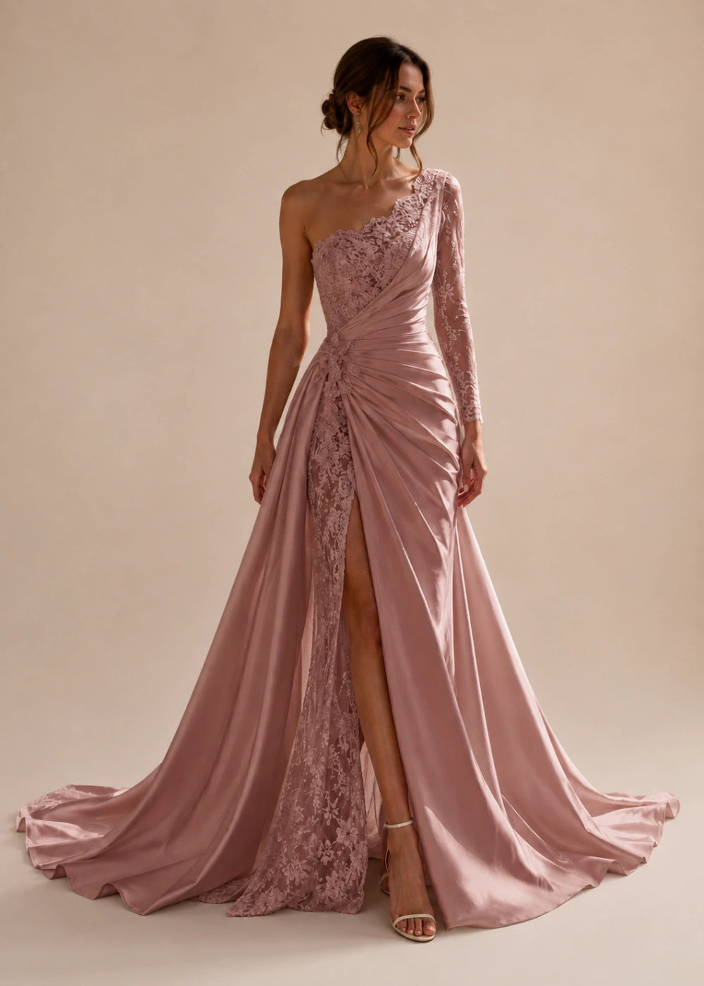 Front view of the dusty rose one-shoulder fitted gown with one long lace sleeve, a thigh-high slit, and a train